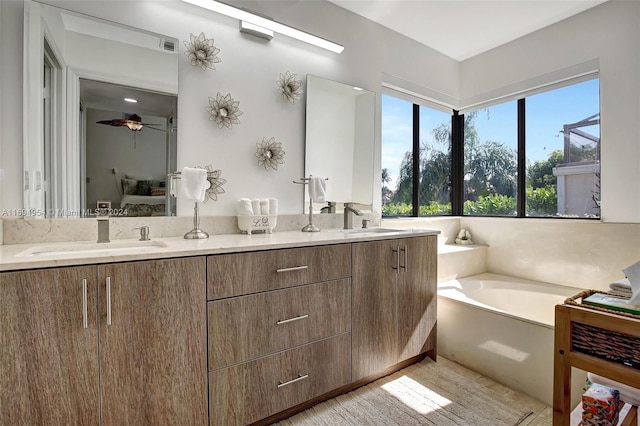 bathroom with ceiling fan, a washtub, and vanity