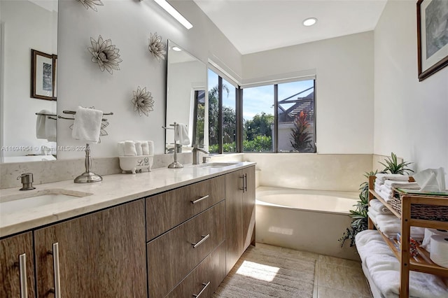 bathroom with a tub, tile patterned flooring, and vanity