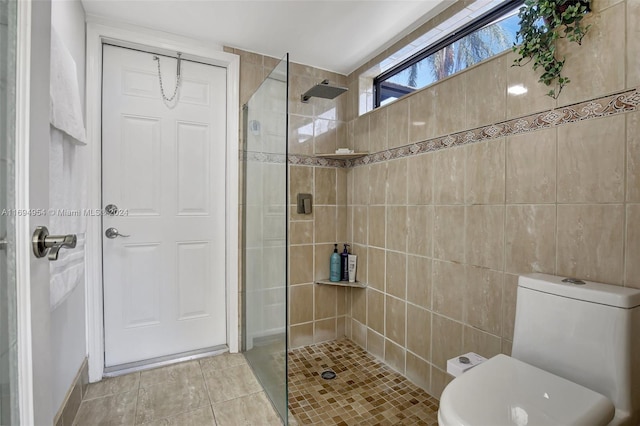 bathroom featuring tile patterned flooring, toilet, and walk in shower