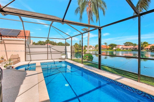 view of pool with glass enclosure and a water view