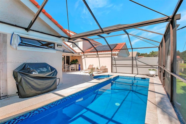 view of swimming pool featuring an in ground hot tub, glass enclosure, a patio area, and a grill