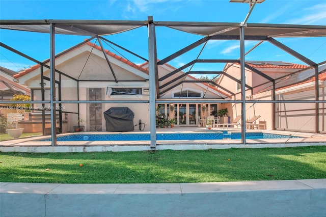 view of pool featuring a lanai, a lawn, and a patio