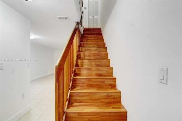 stairway with tile patterned floors