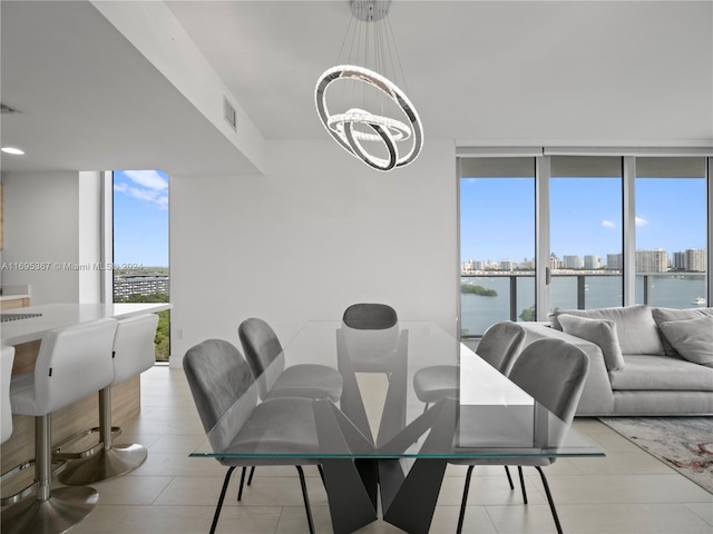 16385 Biscayne Blvd Unit 1615, North Miami Beach, FL 33160 - dining space with a chandelier, expansive windows, a skyline view, light tile patterned floors, and a water view