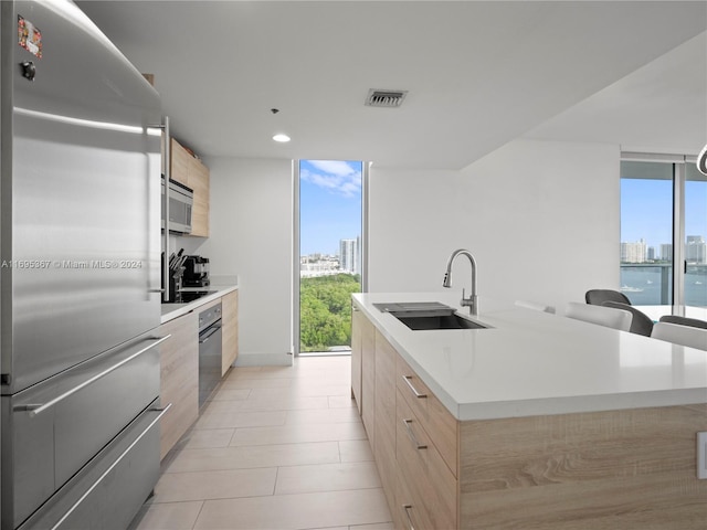 16385 Biscayne Blvd Unit 1615, North Miami Beach, FL 33160 - kitchen featuring appliances with stainless steel finishes, modern cabinets, light brown cabinets, a wall of windows, and recessed lighting