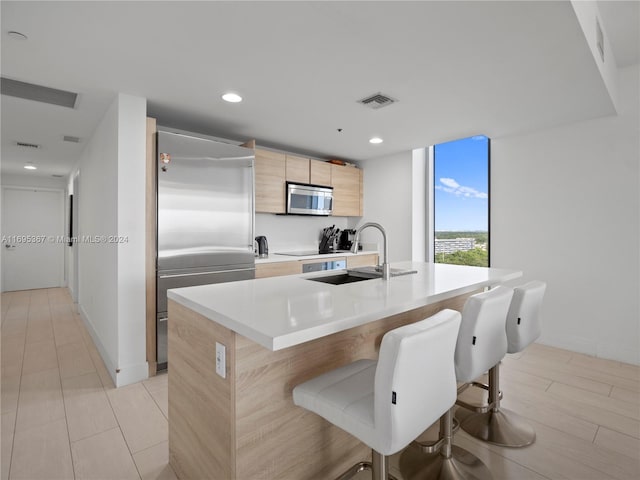 16385 Biscayne Blvd Unit 1615, North Miami Beach, FL 33160 - kitchen with appliances with stainless steel finishes, light brown cabinetry, modern cabinets, a kitchen breakfast bar, and an island with sink