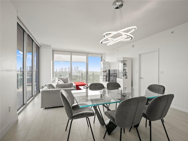 dining room featuring floor to ceiling windows, light hardwood / wood-style flooring, and an inviting chandelier