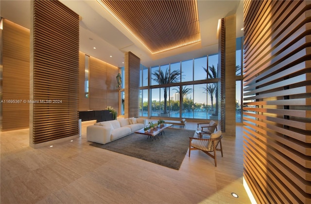 living room with a high ceiling, a raised ceiling, and expansive windows