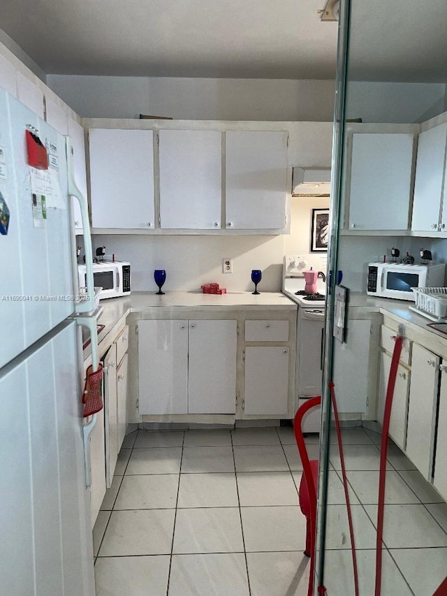2025 NE 164th St Unit 215, North Miami Beach, FL 33162 - kitchen featuring white appliances, light countertops, light tile patterned flooring, and white cabinetry