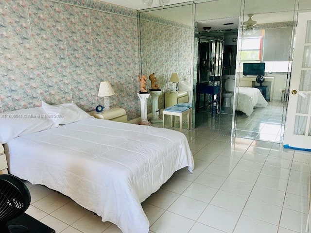 2025 NE 164th St Unit 215, North Miami Beach, FL 33162 - bedroom with wallpapered walls, tile patterned flooring, and a closet