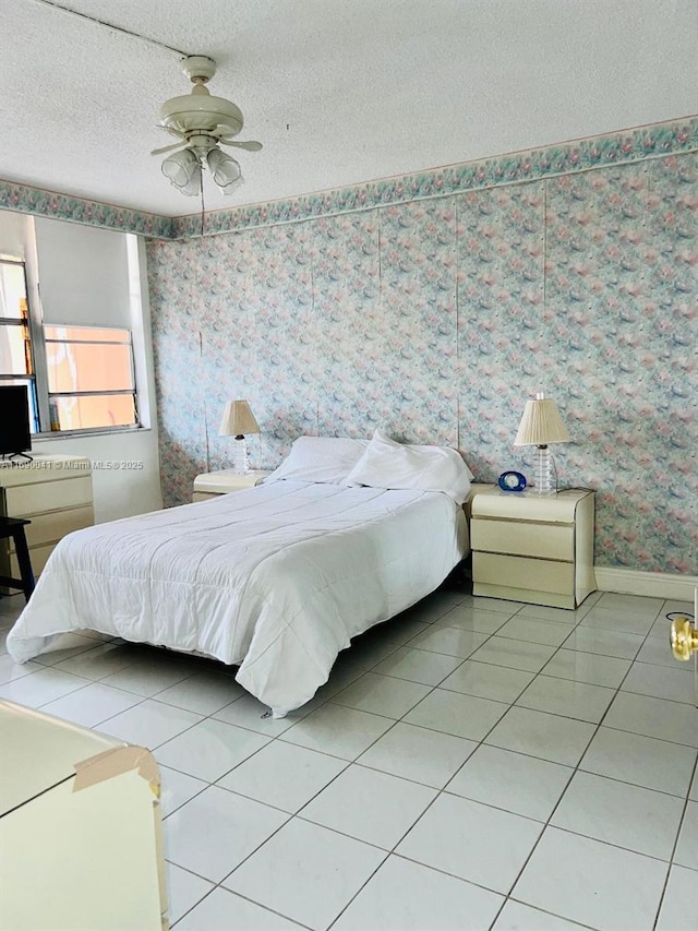 2025 NE 164th St Unit 215, North Miami Beach, FL 33162 - tiled bedroom with wallpapered walls, a textured ceiling, baseboards, and ceiling fan