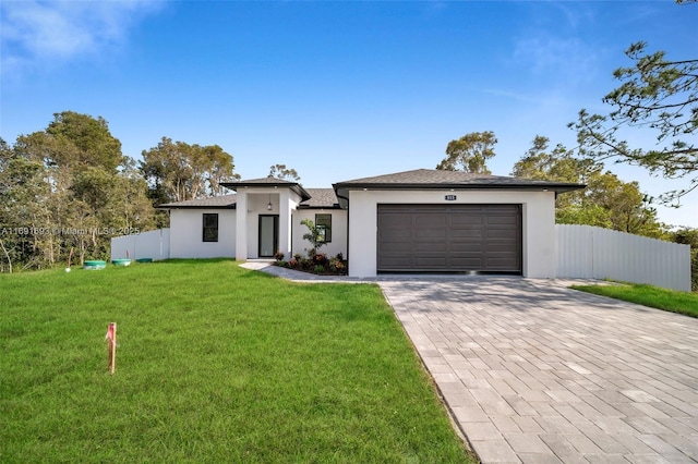 view of front of property featuring a garage and a front lawn