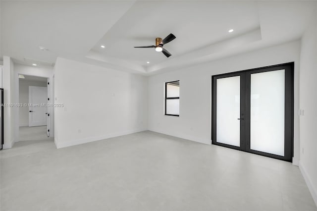 unfurnished room with french doors, ceiling fan, and a tray ceiling