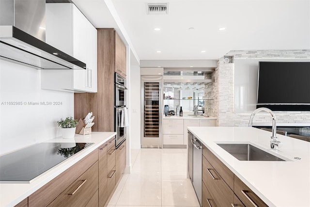 kitchen featuring white cabinetry, sink, beverage cooler, stainless steel appliances, and wall chimney range hood