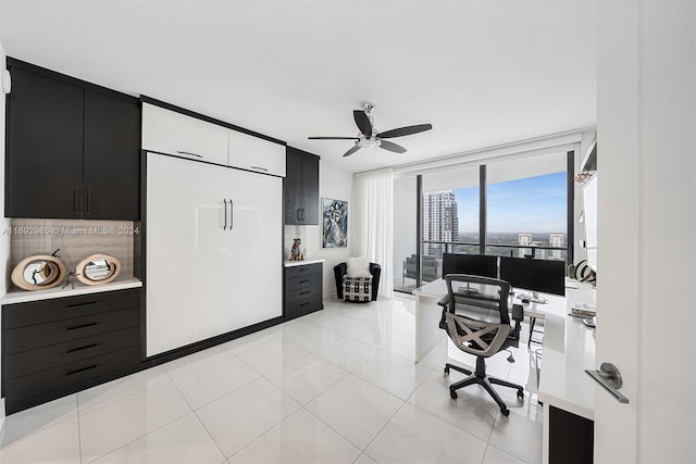 office featuring ceiling fan, expansive windows, and light tile patterned floors