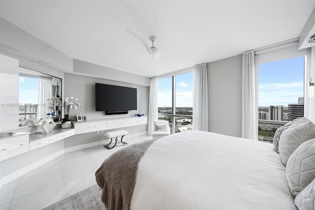 tiled bedroom featuring multiple windows and ceiling fan