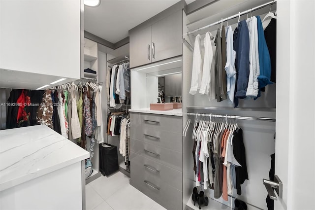 walk in closet with light tile patterned floors