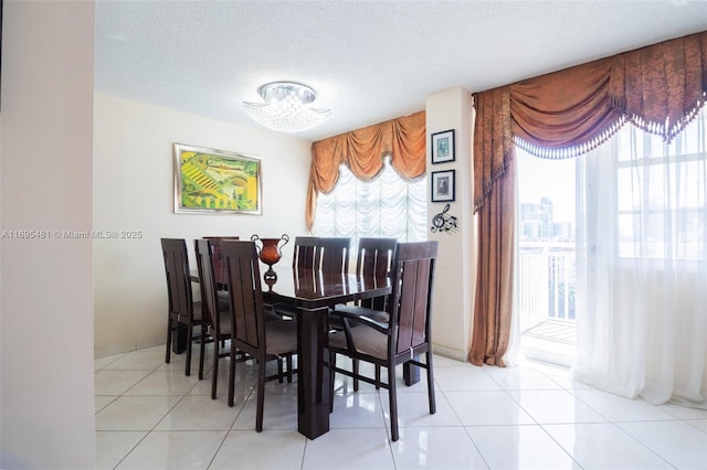 dining space with light tile patterned flooring and a textured ceiling