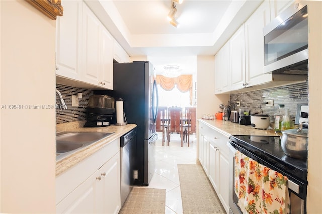 kitchen with white cabinetry, appliances with stainless steel finishes, tasteful backsplash, and light tile patterned floors