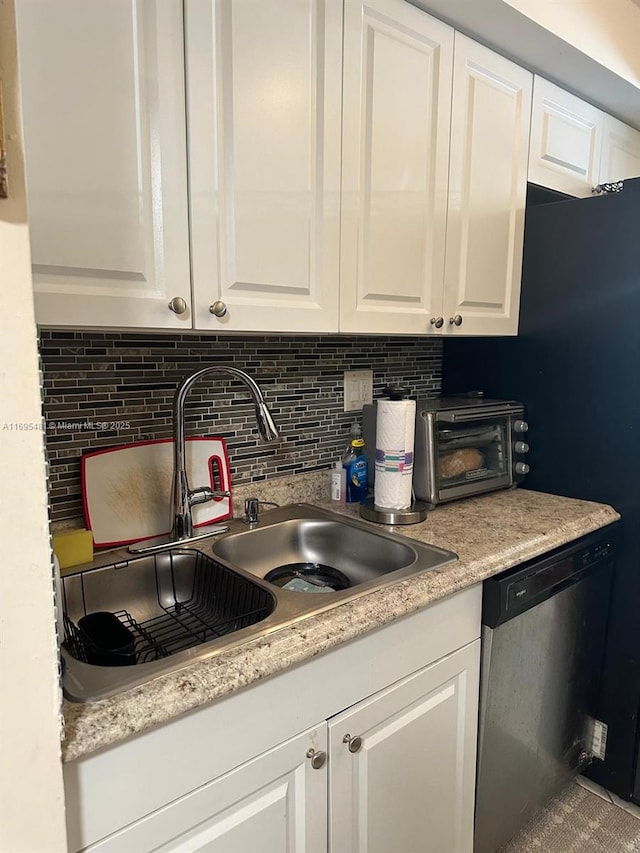 kitchen with tasteful backsplash, dishwasher, sink, and white cabinets