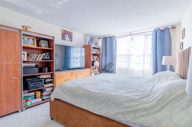 bedroom with light tile patterned floors and a textured ceiling