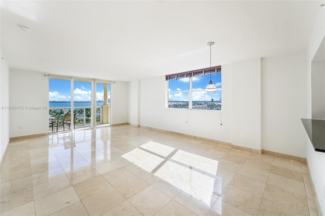 empty room featuring light tile patterned floors and expansive windows