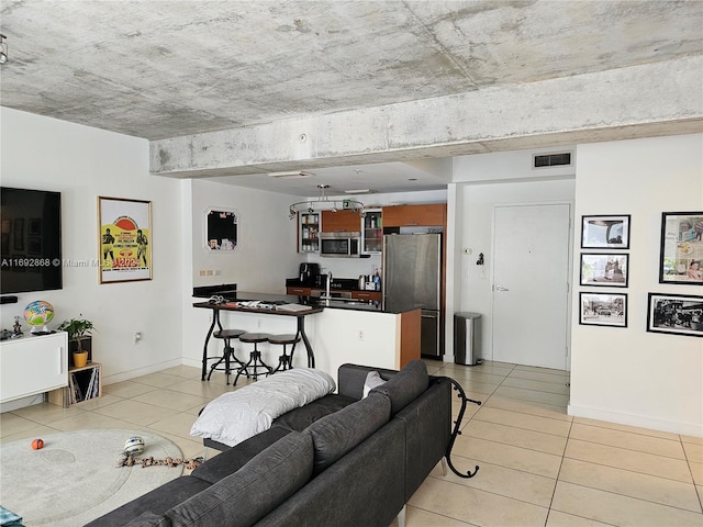 living room featuring sink and light tile patterned floors