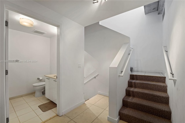 stairway featuring tile patterned flooring