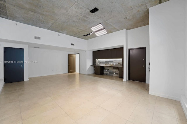 spare room featuring light tile patterned flooring and a high ceiling