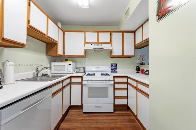 kitchen featuring white appliances, white cabinets, dark wood-type flooring, and sink