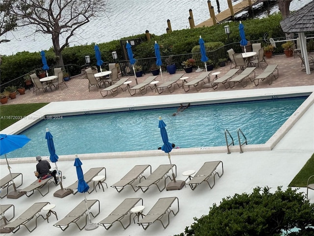 view of pool featuring a patio and a water view