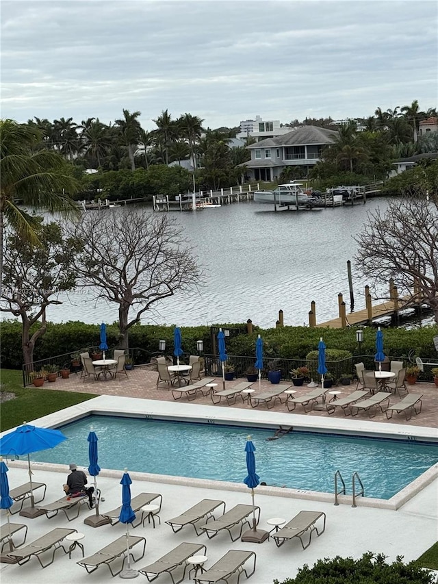 view of swimming pool with a water view and a patio