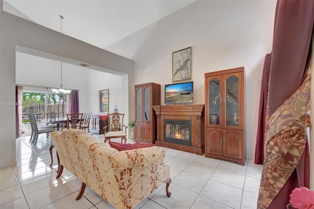 living room featuring a chandelier, high vaulted ceiling, and light tile patterned flooring