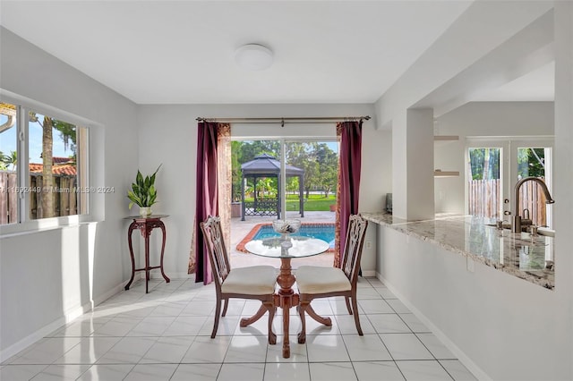 dining area with light tile patterned floors, plenty of natural light, and sink