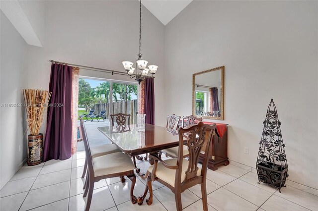 tiled dining area with high vaulted ceiling, a healthy amount of sunlight, and a notable chandelier