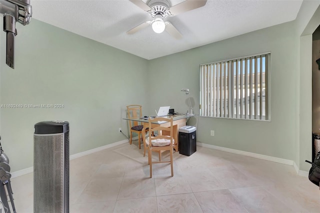 tiled home office featuring a textured ceiling and ceiling fan