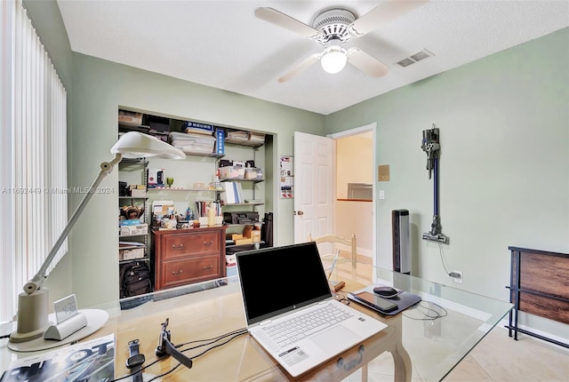 office featuring ceiling fan, light tile patterned flooring, and a textured ceiling