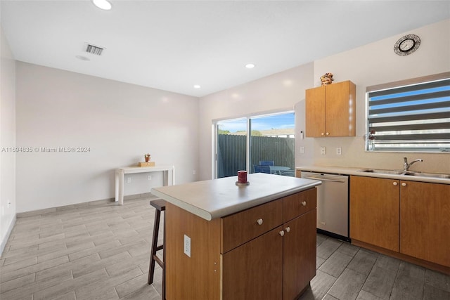 kitchen featuring dishwasher, a center island, light hardwood / wood-style floors, and sink