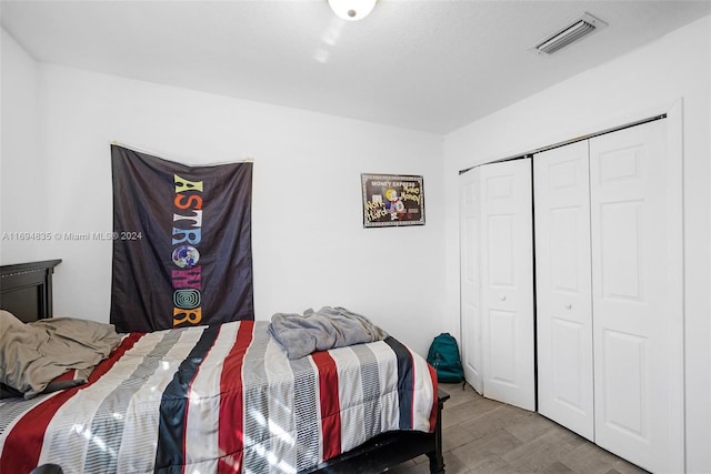 bedroom with a closet and hardwood / wood-style floors