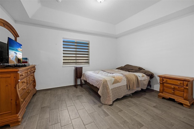 bedroom with a raised ceiling and hardwood / wood-style flooring