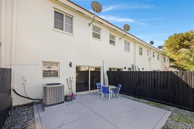 rear view of property with central air condition unit and a patio