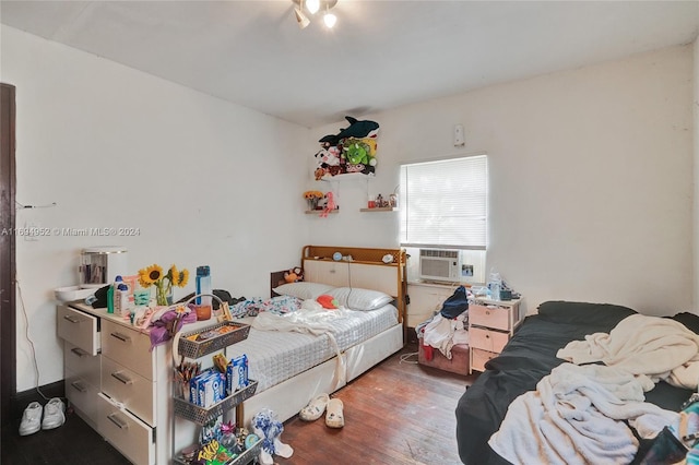 bedroom with dark hardwood / wood-style flooring and cooling unit