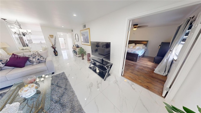 living room featuring wood-type flooring and ceiling fan with notable chandelier