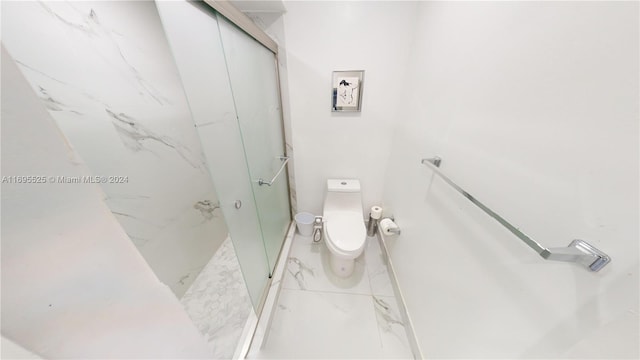 bathroom featuring toilet and an enclosed shower