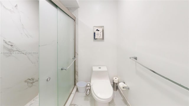 bathroom with toilet and a shower with door