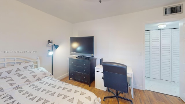 bedroom with light wood-type flooring and a closet