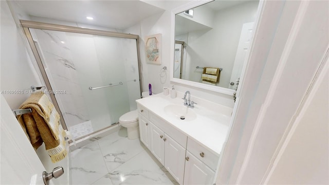 bathroom featuring vanity, a shower with shower door, and toilet