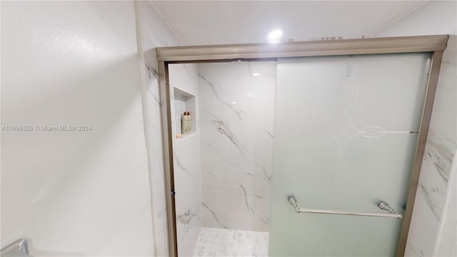 bathroom featuring a shower with shower door