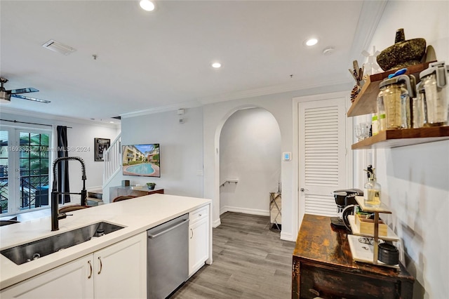 kitchen featuring sink, stainless steel dishwasher, light wood-type flooring, ornamental molding, and white cabinetry