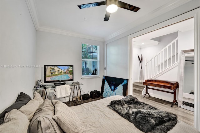 bedroom featuring hardwood / wood-style flooring, ceiling fan, and ornamental molding